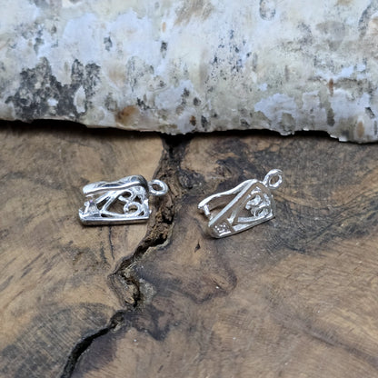Diese 2 Schnörkel-Anhängerösen sind nicht nur stilvoll, sondern auch äußerst vielseitige Schmuckzubehörteile. Mit ihrer glänzenden .925 Sterling Versilberung werden sie zu edlen Komponenten, die sich perfekt als Aufhängevorrichtungen für Schmuckstücke und Edelsteine eignen.
