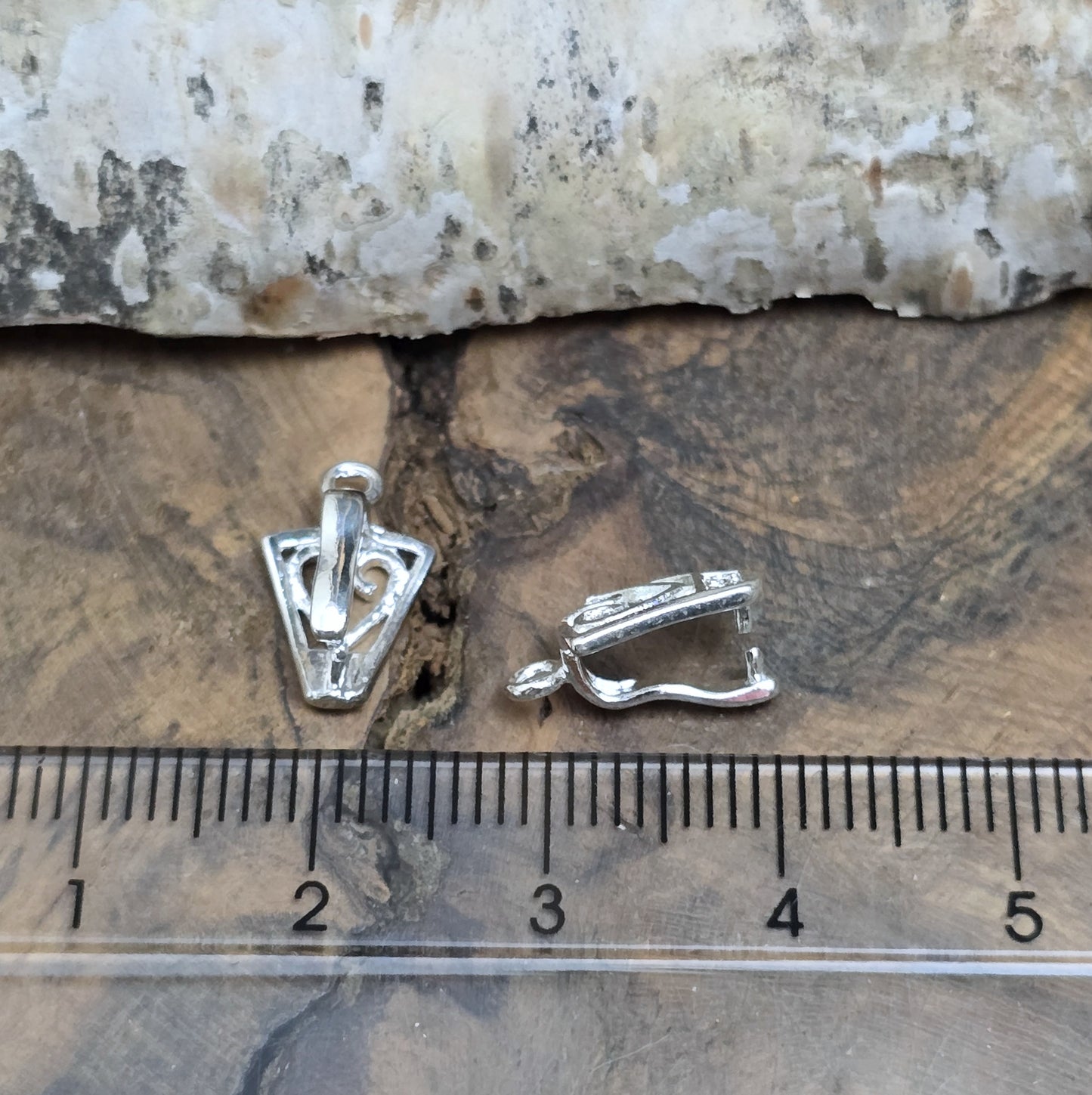 Diese 2 Schnörkel-Anhängerösen sind nicht nur stilvoll, sondern auch äußerst vielseitige Schmuckzubehörteile. Mit ihrer glänzenden .925 Sterling Versilberung werden sie zu edlen Komponenten, die sich perfekt als Aufhängevorrichtungen für Schmuckstücke und Edelsteine eignen.