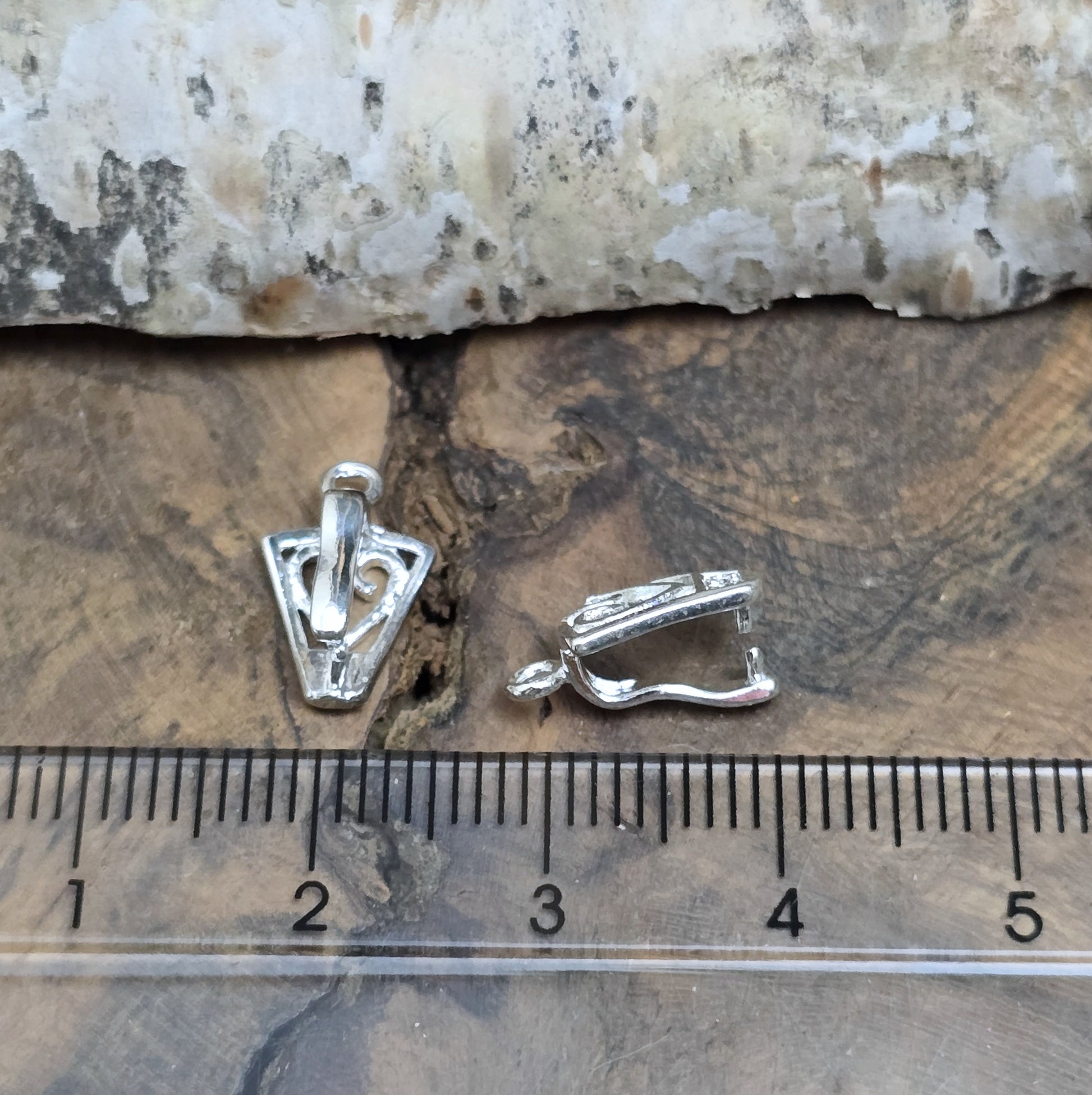 Diese 2 Schnörkel-Anhängerösen sind nicht nur stilvoll, sondern auch äußerst vielseitige Schmuckzubehörteile. Mit ihrer glänzenden .925 Sterling Versilberung werden sie zu edlen Komponenten, die sich perfekt als Aufhängevorrichtungen für Schmuckstücke und Edelsteine eignen.