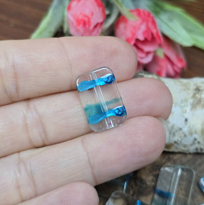 Mit 28 leichten Perlen aus klarem Acryl in Kissenform, die mit faszinierenden petrolfarbenen Akzenten verziert sind, eröffnen sich grenzenlose kreative Möglichkeiten.  Diese vielseitigen Perlen sind nicht nur perfekt für die Schmuckherstellung, sondern auch ideal für DIY-Projekte wie das Gestalten von luftigen Ketten, funkelnden Perlenvorhängen, auffälligen Suncatchern, oder einzigartigen Schlüsselanhängern.