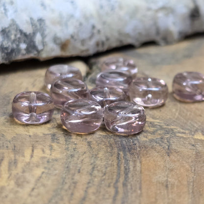 Das Bild zeigt kleine münzförmige Glasperlen in der Farbe Amethyst, für die individuelle Schmuckherstellung.