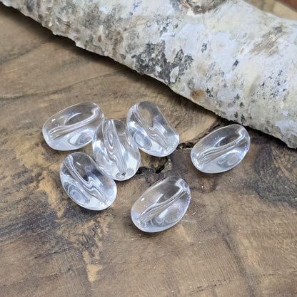 Das Bild zeigt Glasperlen in Nuggetform, farblos transparent. 13mm