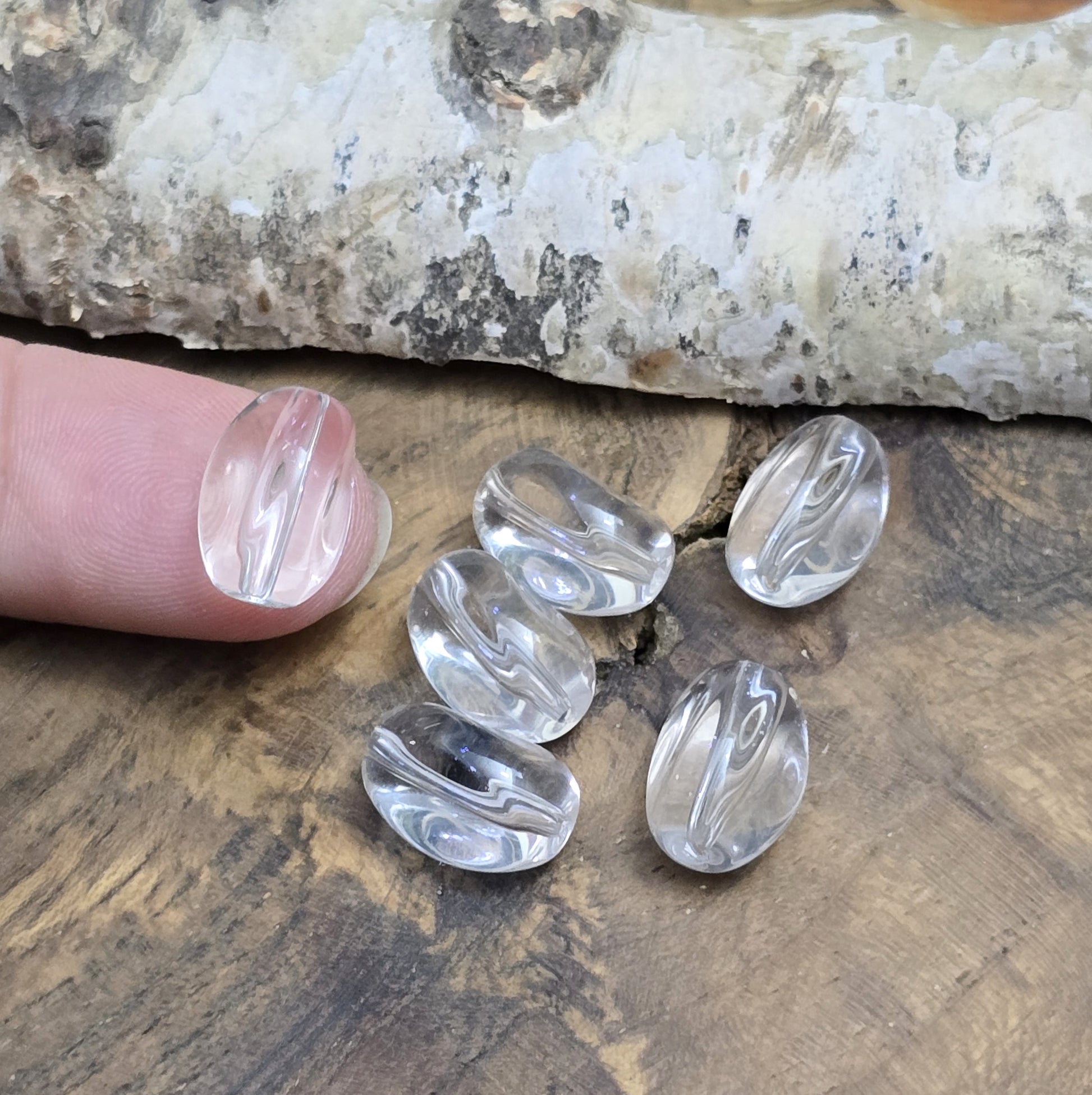 Das Bild zeigt Glasperlen in Nuggetform, farblos transparent. 13mm