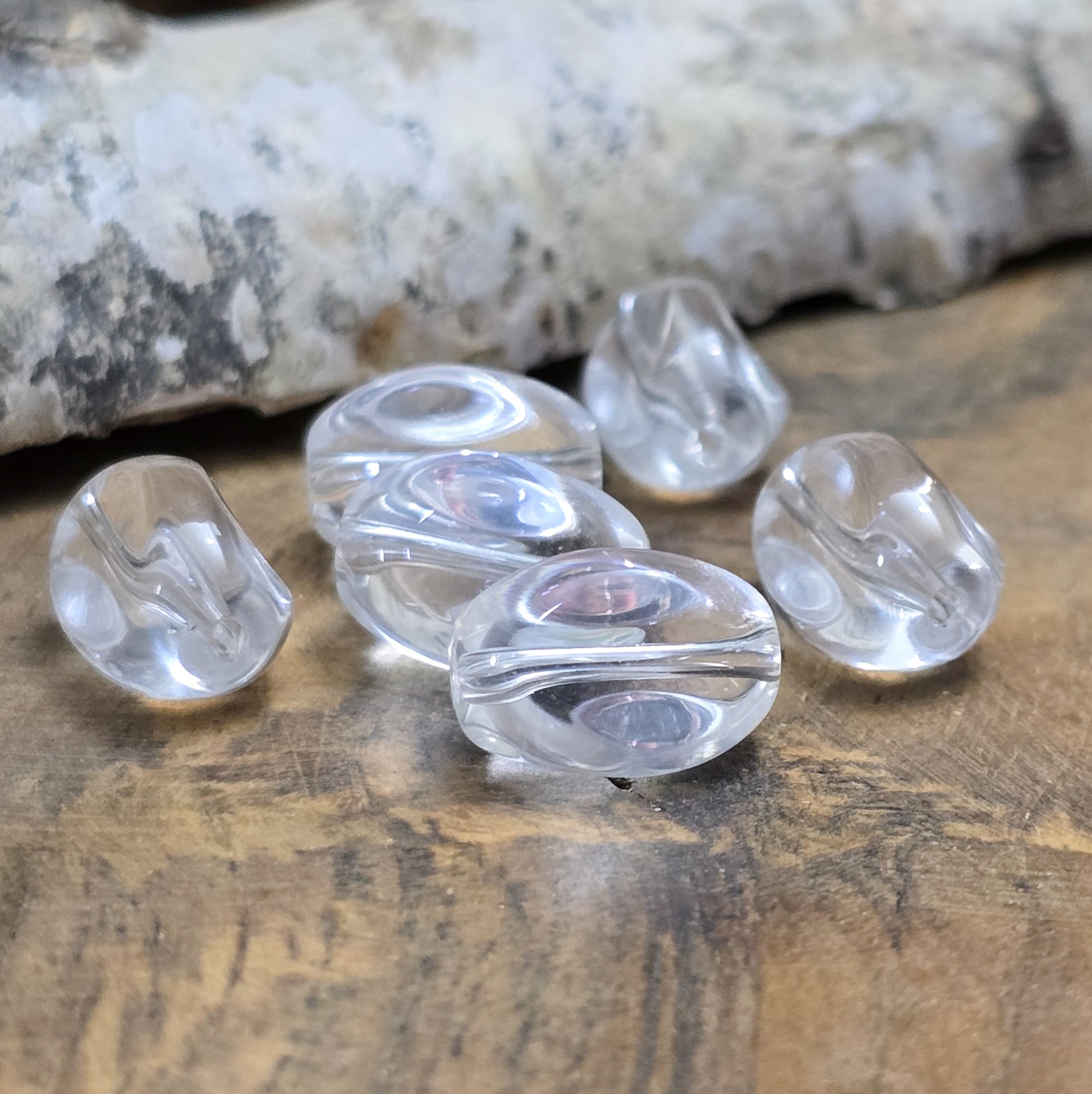 Das Bild zeigt Glasperlen in Nuggetform, farblos transparent. 13mm