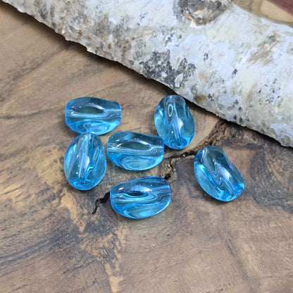 Das Bild zeigt 12 transparente Glasperlen in Nuggetform – Aquablau – 13mm – Für strahlend frische Schmuckkreationen