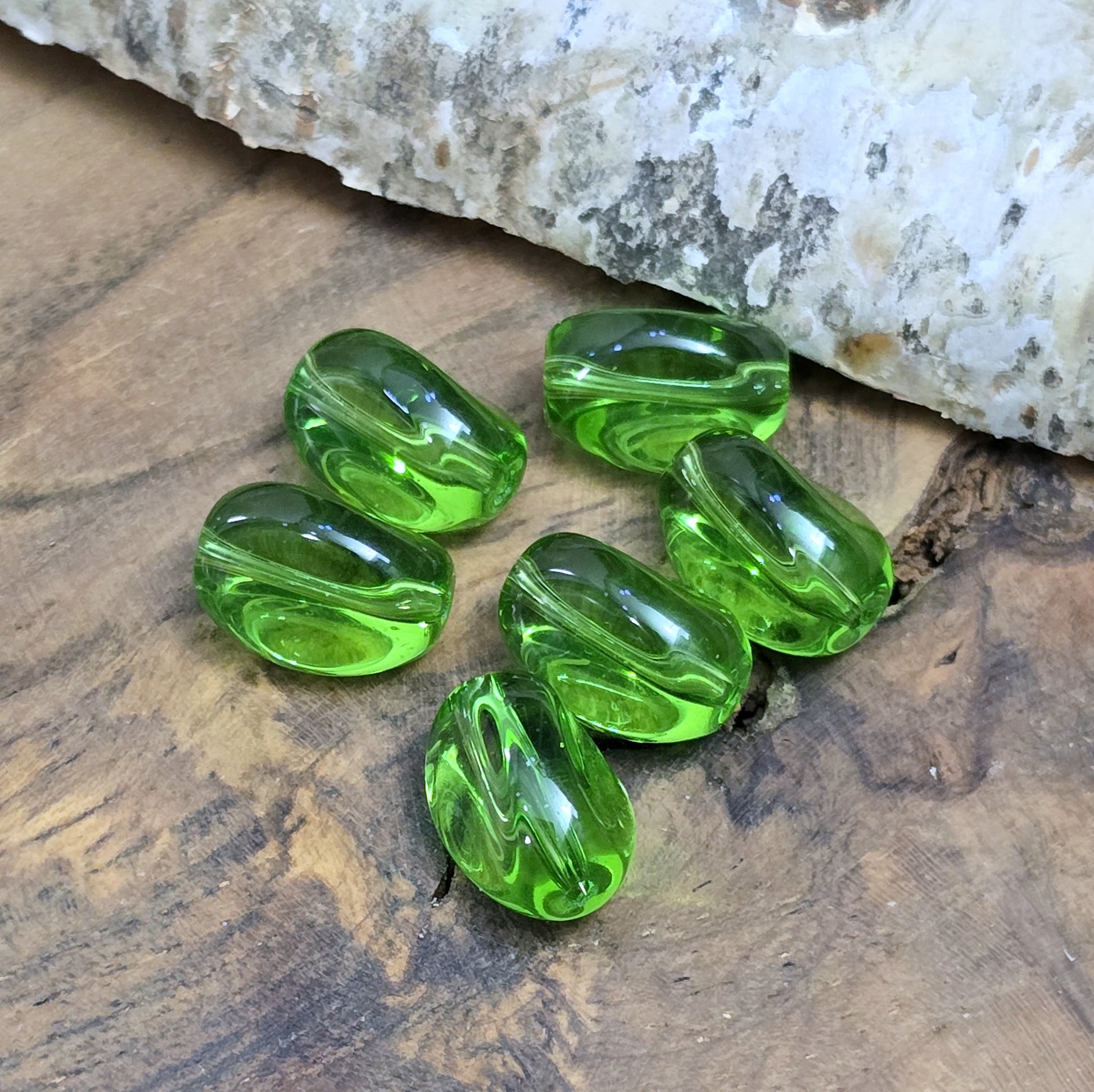 Das Bild zeigt 2 transparente Glasperlen in Nuggetform – Grün – 13mm – Frische Eleganz für deine Schmuckkreationen