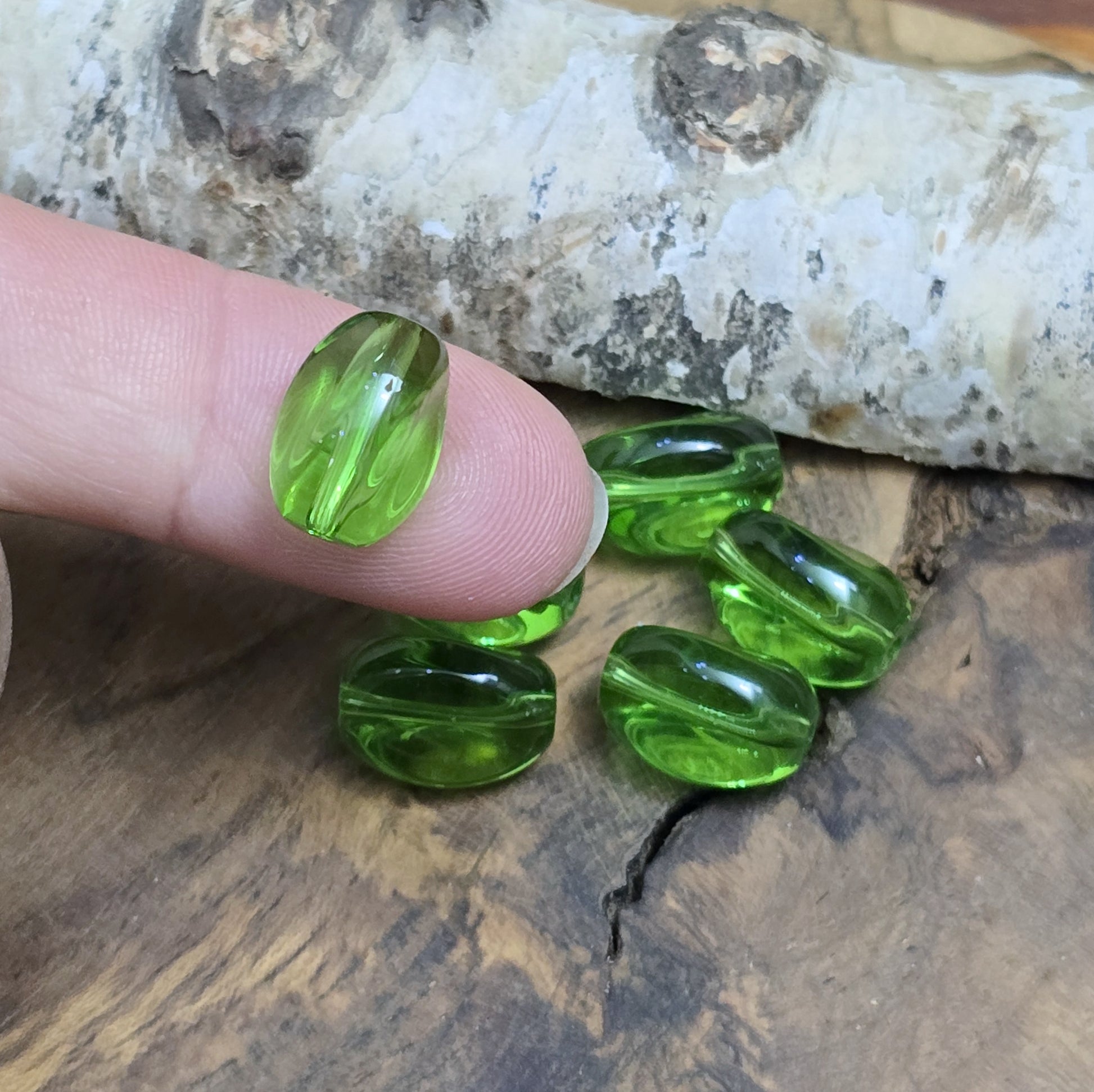 Das Bild zeigt 2 transparente Glasperlen in Nuggetform – Grün – 13mm – Frische Eleganz für deine Schmuckkreationen