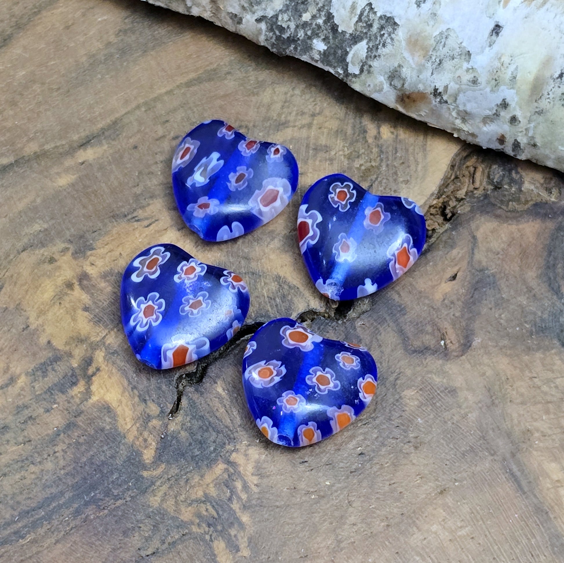 Das Bild zeigt 4 Millefiori Glasperlen – Herzform – Blau – 12mm – Romantische Akzente für deine Schmuckkreationen
