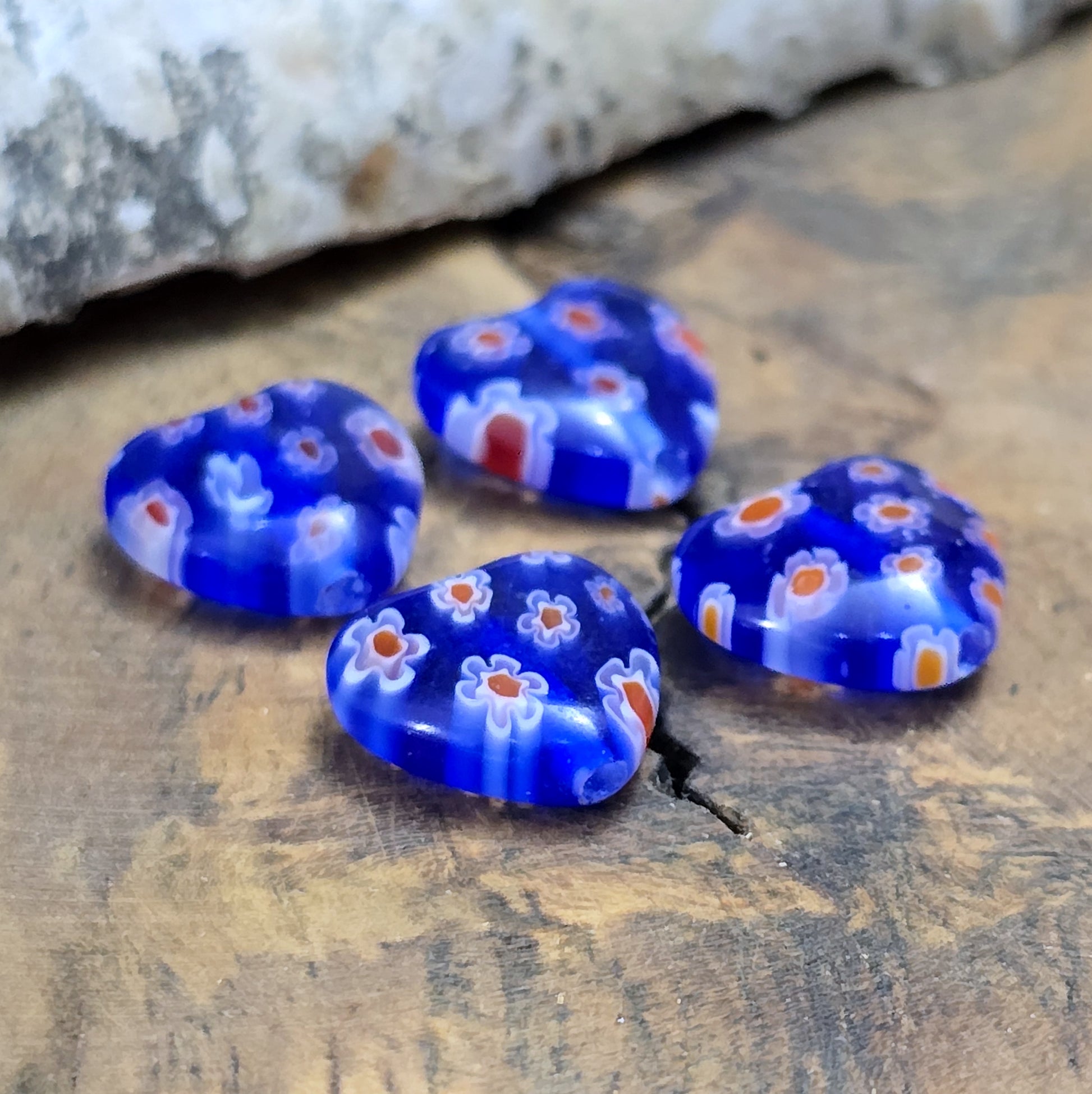 Das Bild zeigt 4 Millefiori Glasperlen – Herzform – Blau – 12mm – Romantische Akzente für deine Schmuckkreationen