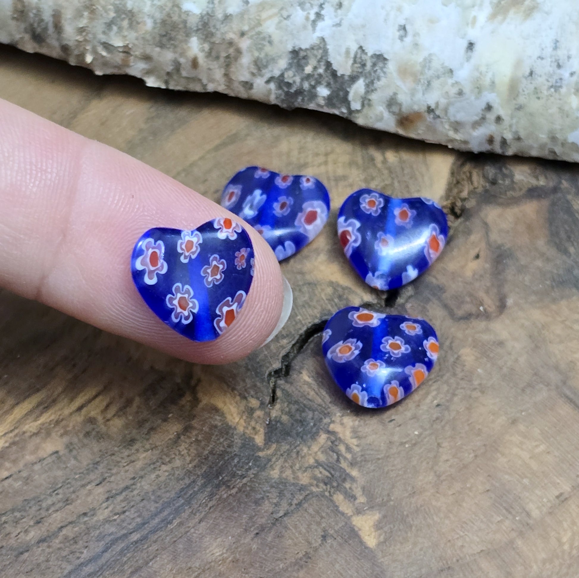 Das Bild zeigt 4 Millefiori Glasperlen – Herzform – Blau – 12mm – Romantische Akzente für deine Schmuckkreationen