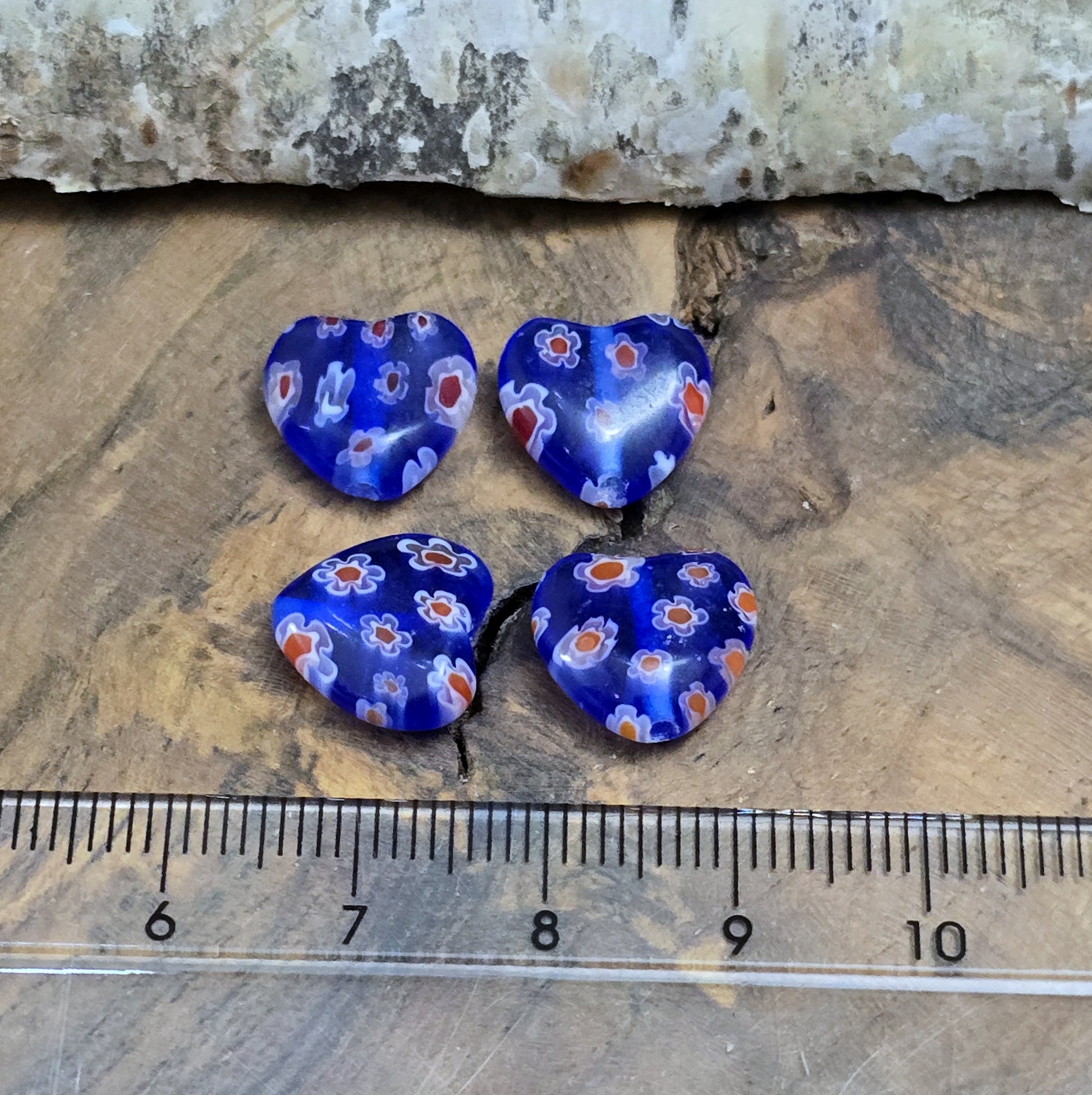 Das Bild zeigt 4 Millefiori Glasperlen – Herzform – Blau – 12mm – Romantische Akzente für deine Schmuckkreationen