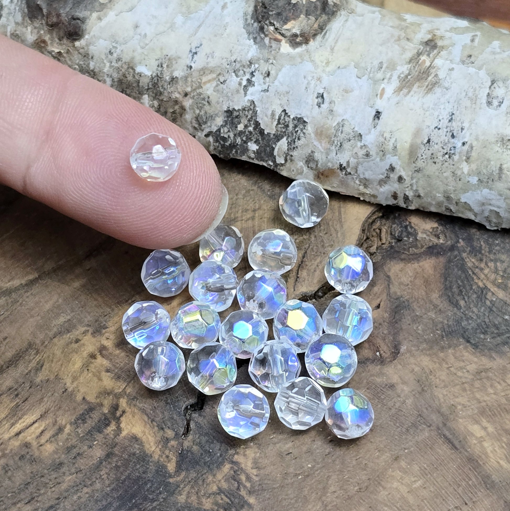 Das Bild zeigt 40 kleine facettierte Glasperlen – Kugel – 6mm – Crystal AB – Funkelnde Eleganz für deine Schmuckkreationen