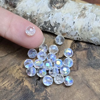 Das Bild zeigt 40 kleine facettierte Glasperlen – Kugel – 6mm – Crystal AB – Funkelnde Eleganz für deine Schmuckkreationen