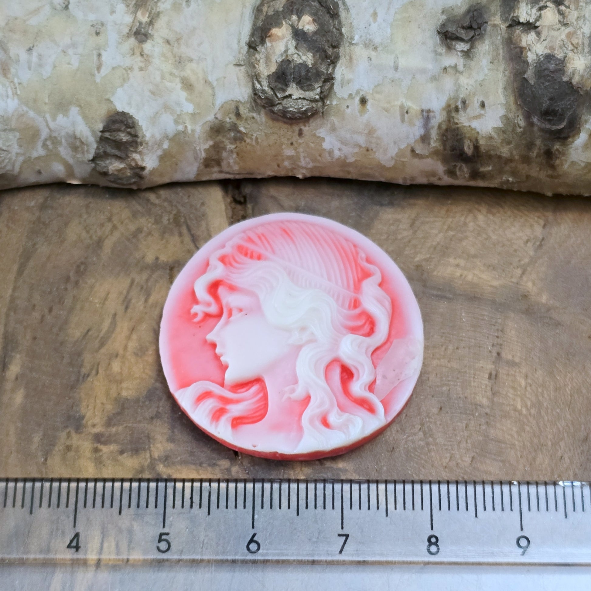 Das Bild zeigt einen runden Kamee-Cabochon – 31mm – Lachsrot – Vintage-Charme für deine kreativen Projekte