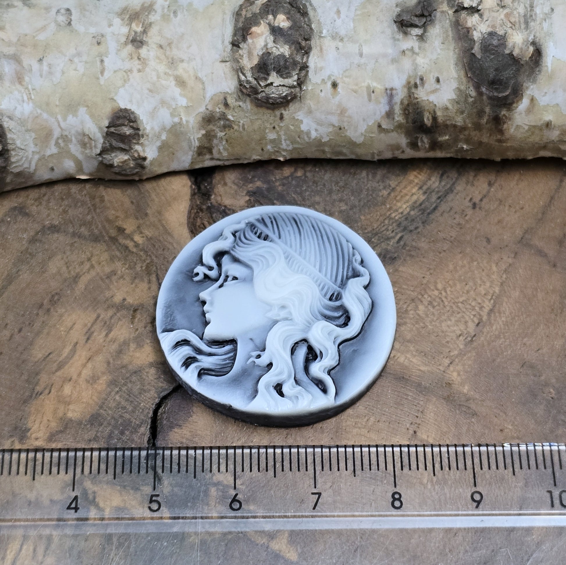 Das Bild zeigt einen runden Kamee-Cabochon – 31mm – Schwarz – Klassische Eleganz für deine DIY-Projekte