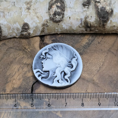 Das Bild zeigt einen runden Kamee-Cabochon – 31mm – Schwarz – Klassische Eleganz für deine DIY-Projekte