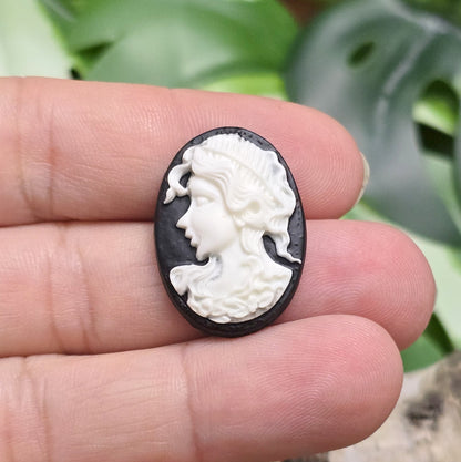Das Bild zeigt einen ovalen Kamee-Cabochon – 25 x 18mm – Schwarz mit weißem Relief – Vintage-Charme für deine DIY-Kreationen