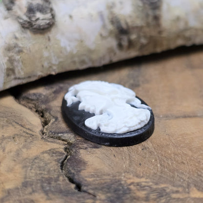 Das Bild zeigt einen ovalen Kamee-Cabochon – 25 x 18mm – Schwarz mit weißem Relief – Vintage-Charme für deine DIY-Kreationen