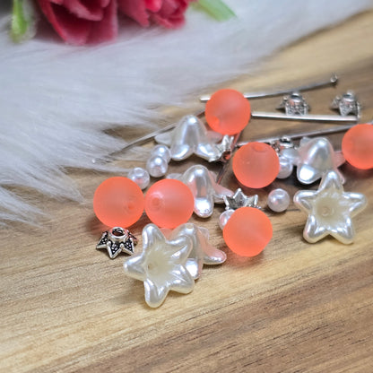 Das Bild zeigt ein 30-teiliges Bastelset zur Schmuckherstellung, ideal für kreative Bastler. In dem Set sind Materialien enthalten, um 6 Blumenanhänger in Orange und Weiß zu gestalten. Zu sehen sind verschiedene Komponenten: matte orangefarbene Glasperlen, cremeweiße Acrylperlen, weiße Blütenkäppchen und antik silberfarbige Sternkäppchen. Alle Teile sind sorgfältig angeordnet, um die Vielseitigkeit und Farbpalette des Sets hervorzuheben. Dieses Set bietet die perfekte Grundlage für die Gestaltung einzigarti