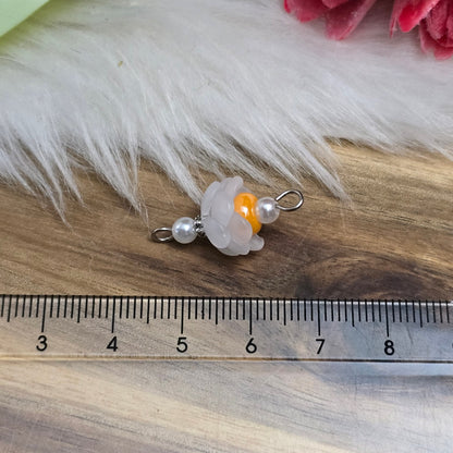 Auf dem Bild sind zwei handgefertigte Blütenverbinder zu sehen. Diese bestehen aus mattierten, weißen Acrylblütenkäppchen, die harmonisch mit cremefarbenen Acrylperlen und leuchtenden, orangen böhmischen Glasperlen kombiniert sind. Die Verbinder haben eine Länge von ca. 24mm und eine Breite von 12mm. Sie sind ideal für kreative Schmuckprojekte und verleihen Armbändern, Halsketten und Ohrringen einen frischen, romantischen Look.