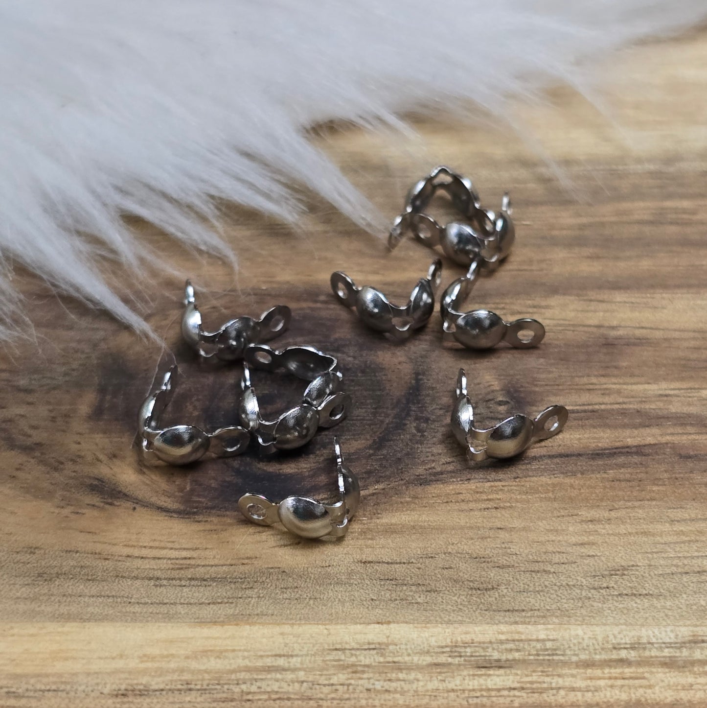 Die Edelstahl Quetschkalotten in Silberfarbe messen 8x4 mm und kommen in einer praktischen Packung mit 10 Stück. Diese kleinen Metallkappen eignen sich perfekt zur sicheren Befestigung von Perlen und Anhängern an Draht oder Schnur, sorgen für ein professionelles Finish und verleihen deinem Schmuckdesign Eleganz und Stabilität.