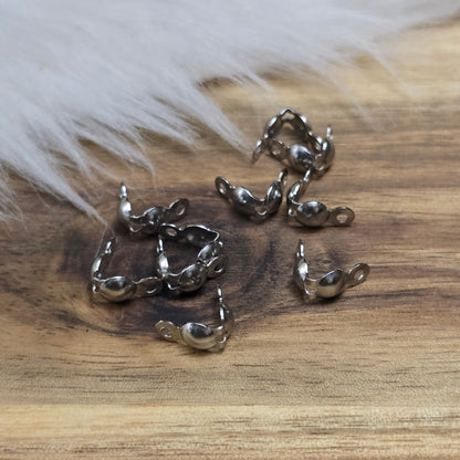 Die Edelstahl Quetschkalotten in Silberfarbe messen 8x4 mm und kommen in einer praktischen Packung mit 10 Stück. Diese kleinen Metallkappen eignen sich perfekt zur sicheren Befestigung von Perlen und Anhängern an Draht oder Schnur, sorgen für ein professionelles Finish und verleihen deinem Schmuckdesign Eleganz und Stabilität.