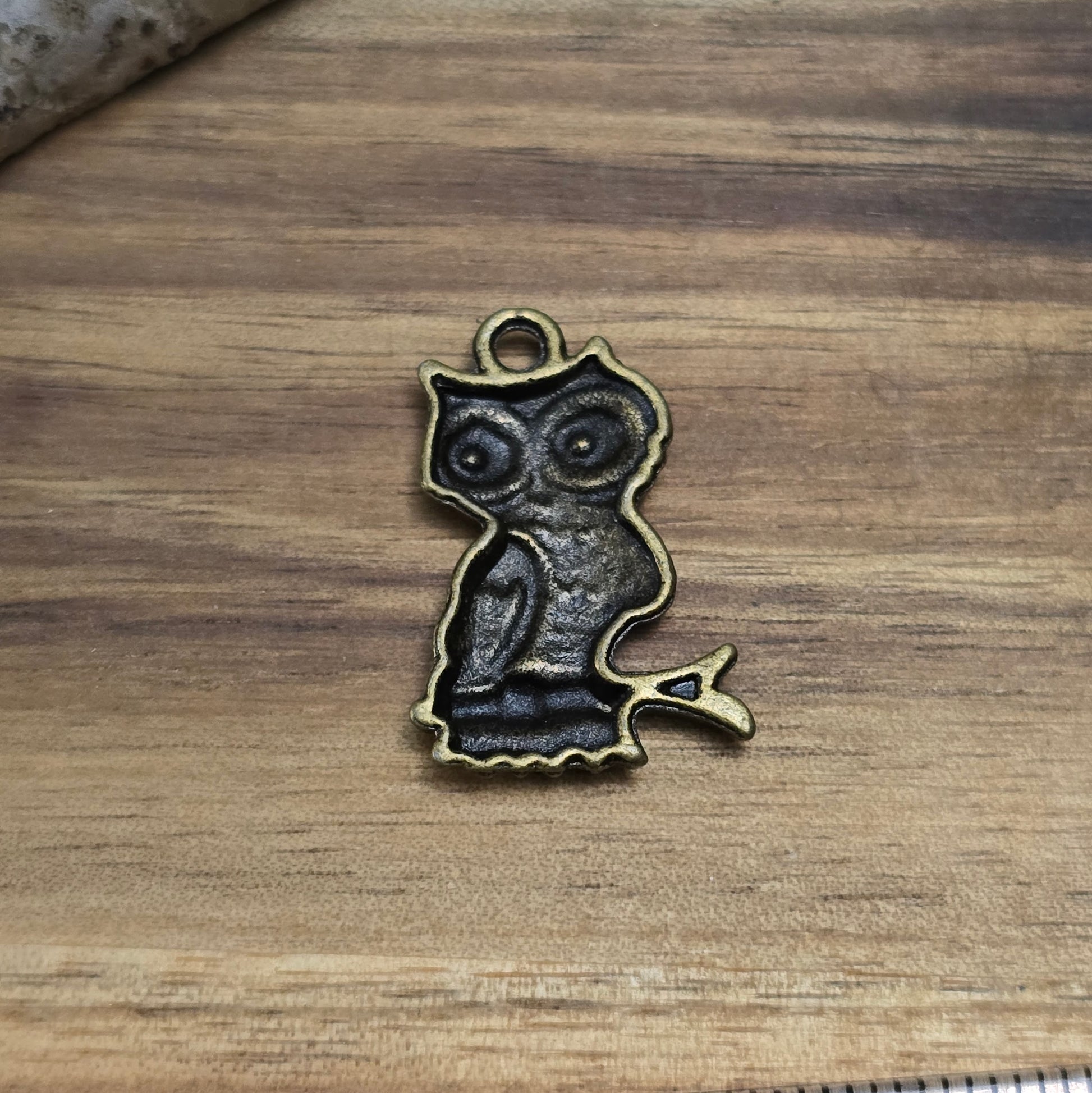Das Bild zeigt vier bronzefarbene Eulen-Anhänger mit einer detailreichen Gravur. Die Charms sind ca. 22 mm groß und haben eine hohle Rückseite, was sie besonders leicht macht. Perfekt für Ketten, Armbänder oder andere Schmuckprojekte im Vintage- oder Boho-Stil.