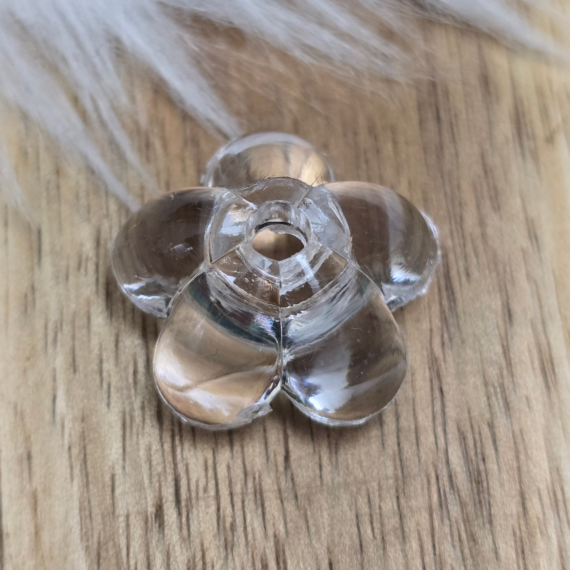 Klar transparente Acryl-Blumenperlen (18 mm) mit glänzender Oberfläche. Die filigrane Blütenform verleiht Schmuckstücken und Dekorationen eine elegante Note. Mit einem 3,5 mm großen Fädelloch lassen sie sich leicht auf Bänder oder Schnüre auffädeln. Ideal für DIY-Projekte, Hochzeiten oder Bastelarbeiten.
