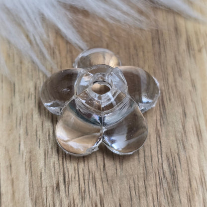 Klar transparente Acryl-Blumenperlen (18 mm) mit glänzender Oberfläche. Die filigrane Blütenform verleiht Schmuckstücken und Dekorationen eine elegante Note. Mit einem 3,5 mm großen Fädelloch lassen sie sich leicht auf Bänder oder Schnüre auffädeln. Ideal für DIY-Projekte, Hochzeiten oder Bastelarbeiten.