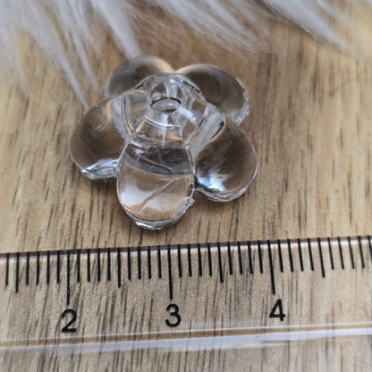 Klar transparente Acryl-Blumenperlen (18 mm) mit glänzender Oberfläche. Die filigrane Blütenform verleiht Schmuckstücken und Dekorationen eine elegante Note. Mit einem 3,5 mm großen Fädelloch lassen sie sich leicht auf Bänder oder Schnüre auffädeln. Ideal für DIY-Projekte, Hochzeiten oder Bastelarbeiten.