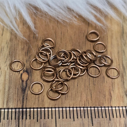 Das Bild zeigt 30 offene Biegeringe antik kupferfarbig mit 4,2mm Durchmesser, perfekt für die Schmuckherstellung. Sie eignen sich hervorragend als Anhängerösen für Kettenanhänger oder als Verbindungsringe in verschiedenen Designs.