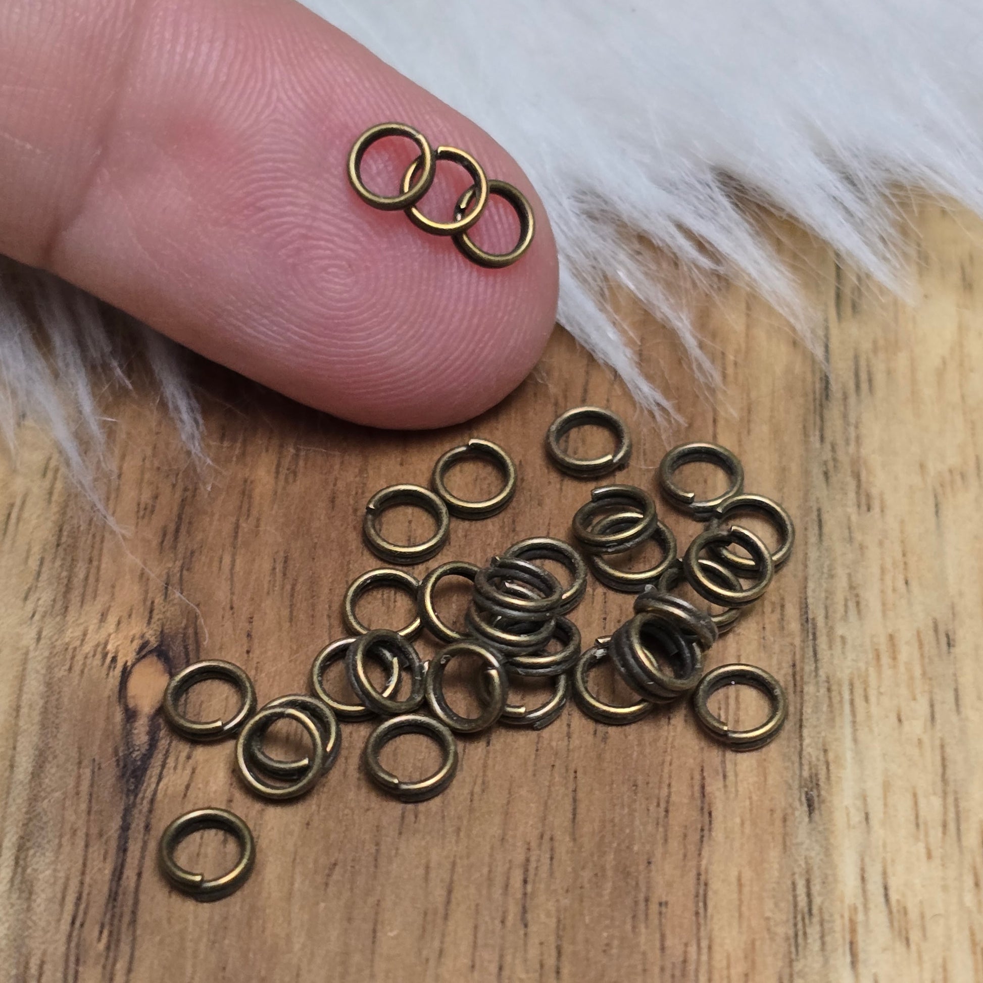 Das Bild zeigt 30 doppelte Binderinge in antikem Bronze-Finish mit 4mm im Durchmesser, ein unverzichtbares Zubehör für die Schmuckherstellung. Durch ihre doppelte Wicklung bieten sie eine besonders stabile und sichere Verbindung, sodass Anhänger, Charms und Verschlüsse zuverlässig befestigt bleiben.
