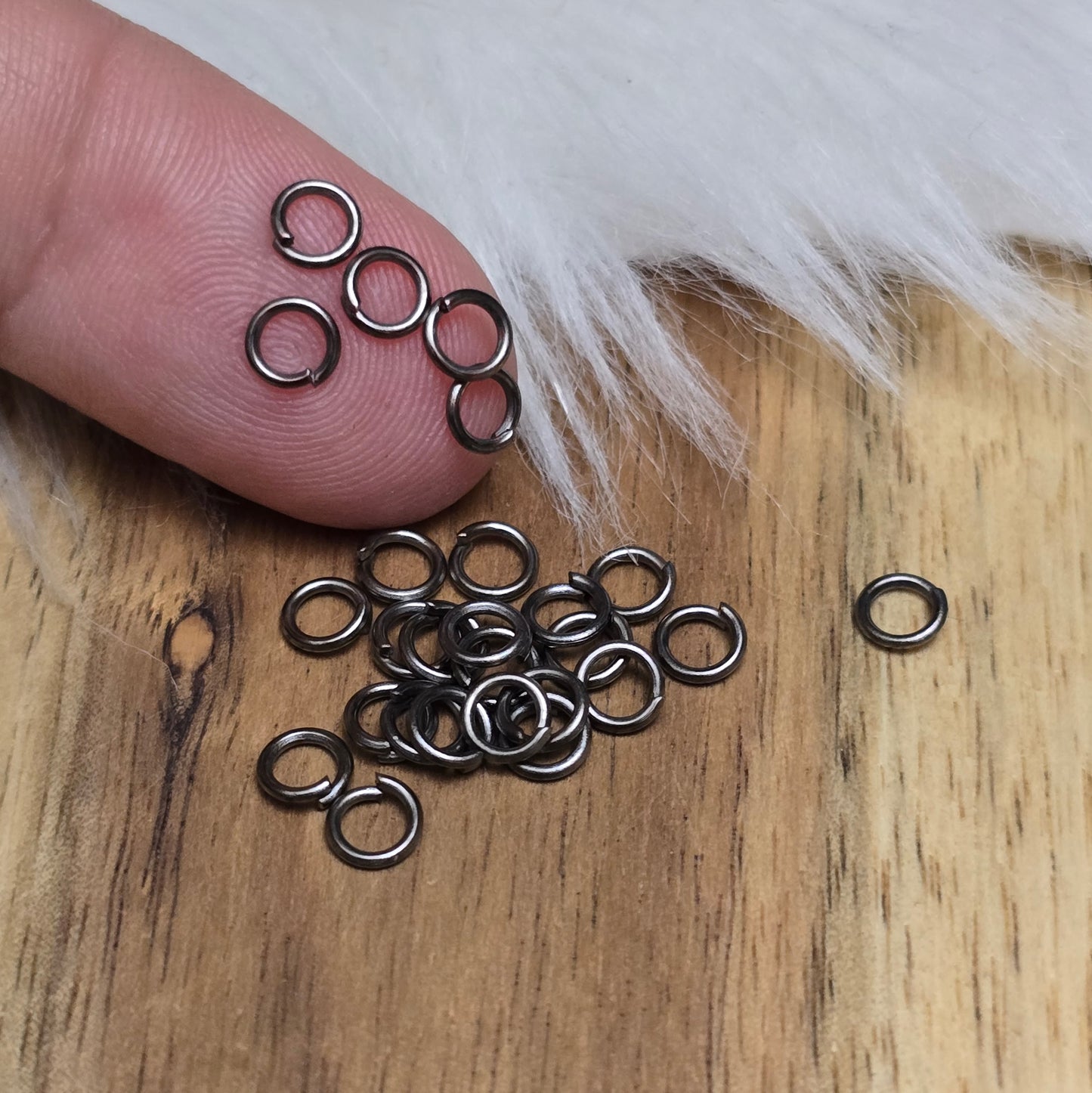Das Bild zeigt 30 offene Biegeringe in gunmetal black mit 4,2mm Durchmesser, ein unverzichtbares Zubehör für die Schmuckherstellung. Ideal um Charms und Verschlüsse zuverlässig zu befestigen.