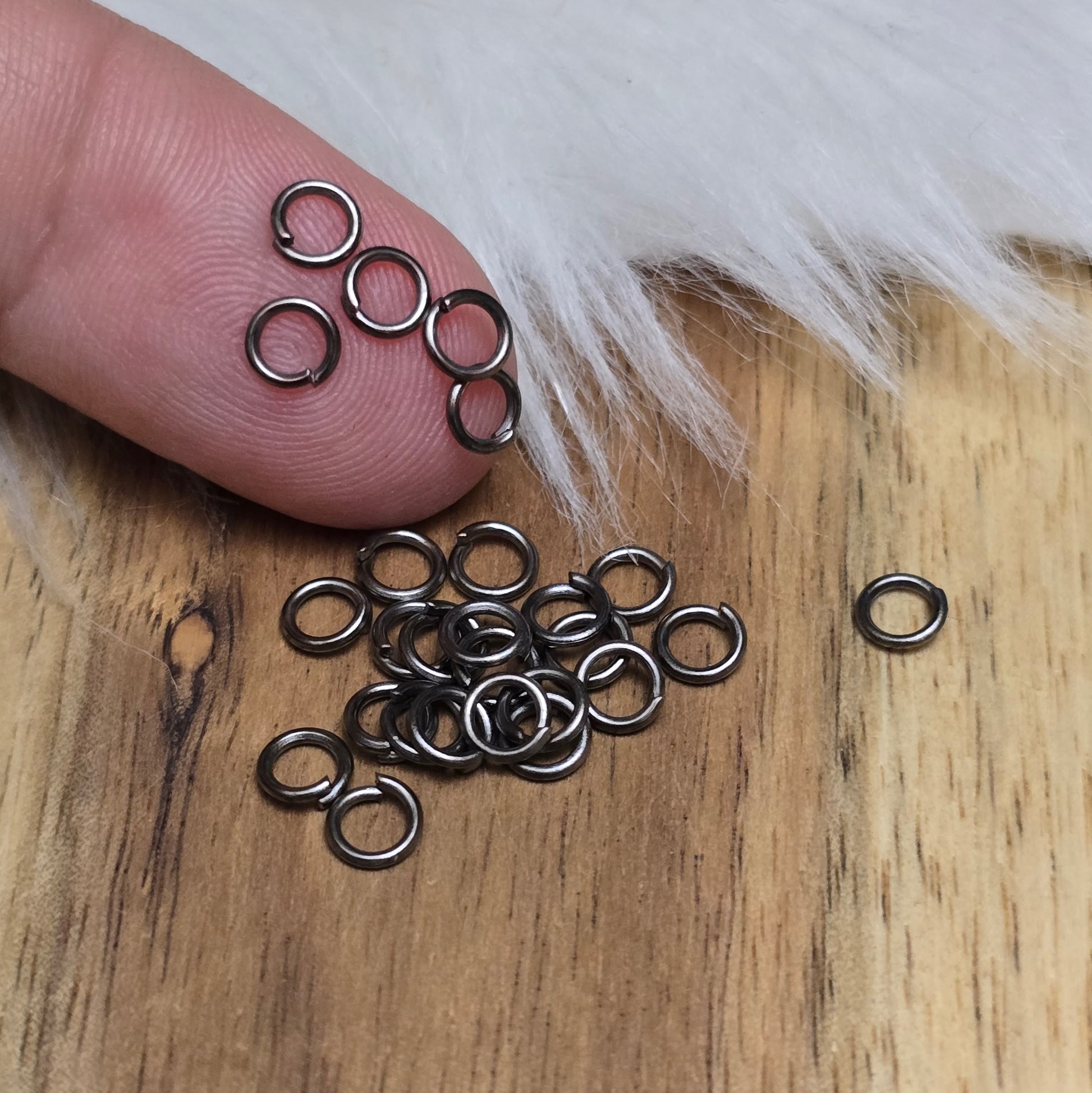 Das Bild zeigt 30 offene Biegeringe in gunmetal black mit 4,2mm Durchmesser, ein unverzichtbares Zubehör für die Schmuckherstellung. Ideal um Charms und Verschlüsse zuverlässig zu befestigen.