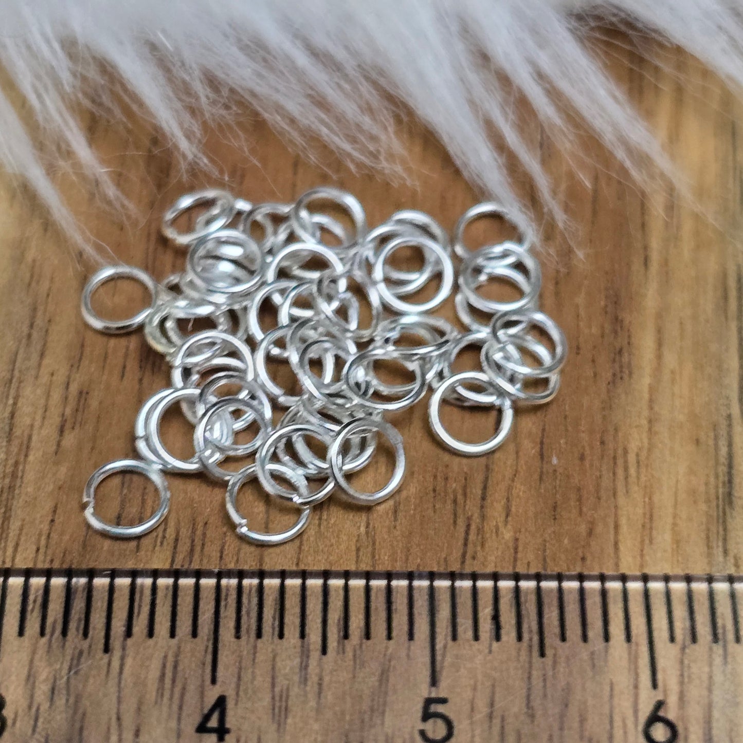 Das Bild zeigt 40 offene Biegeringe in versilbert mit einem Durchmesser von 4,2mm, ein unverzichtbares Zubehör für die Schmuckherstellung. Ideal um Charms und Verschlüsse zuverlässig zu befestigen.