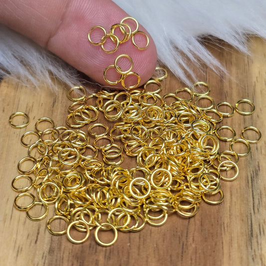 Das Bild zeigt 100 offene Biegeringe in vergoldet mit einem Durchmesser von 4mm, ein unverzichtbares Zubehör für die Schmuckherstellung. Ideal um Charms und Verschlüsse zuverlässig zu befestigen.