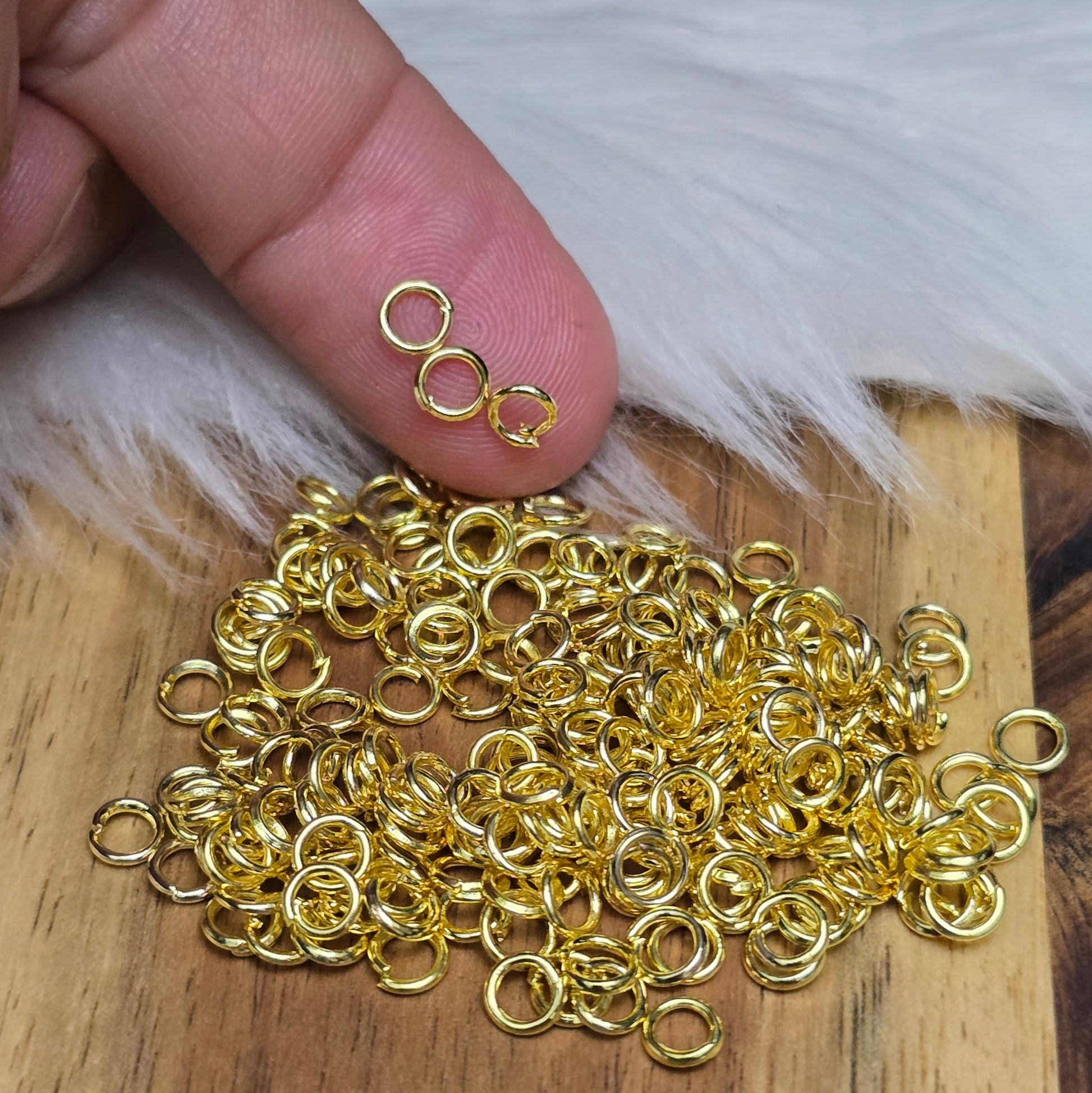 Das Bild zeigt 100 offenen Biegeringe in vergoldet mit einem Durchmesser von 4,2mm, ein unverzichtbares Zubehör für die Schmuckherstellung. Ideal um Charms und Verschlüsse zuverlässig zu befestigen.