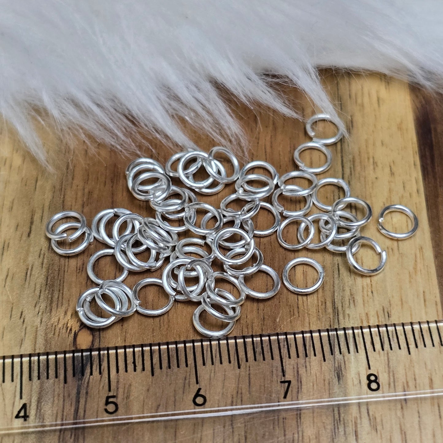 Das Bild zeigt 50 offene Biegeringe in versilbert mit einem Durchmesser von 5mm, ein unverzichtbares Zubehör für die Schmuckherstellung. Ideal um Charms und Verschlüsse zuverlässig zu befestigen.