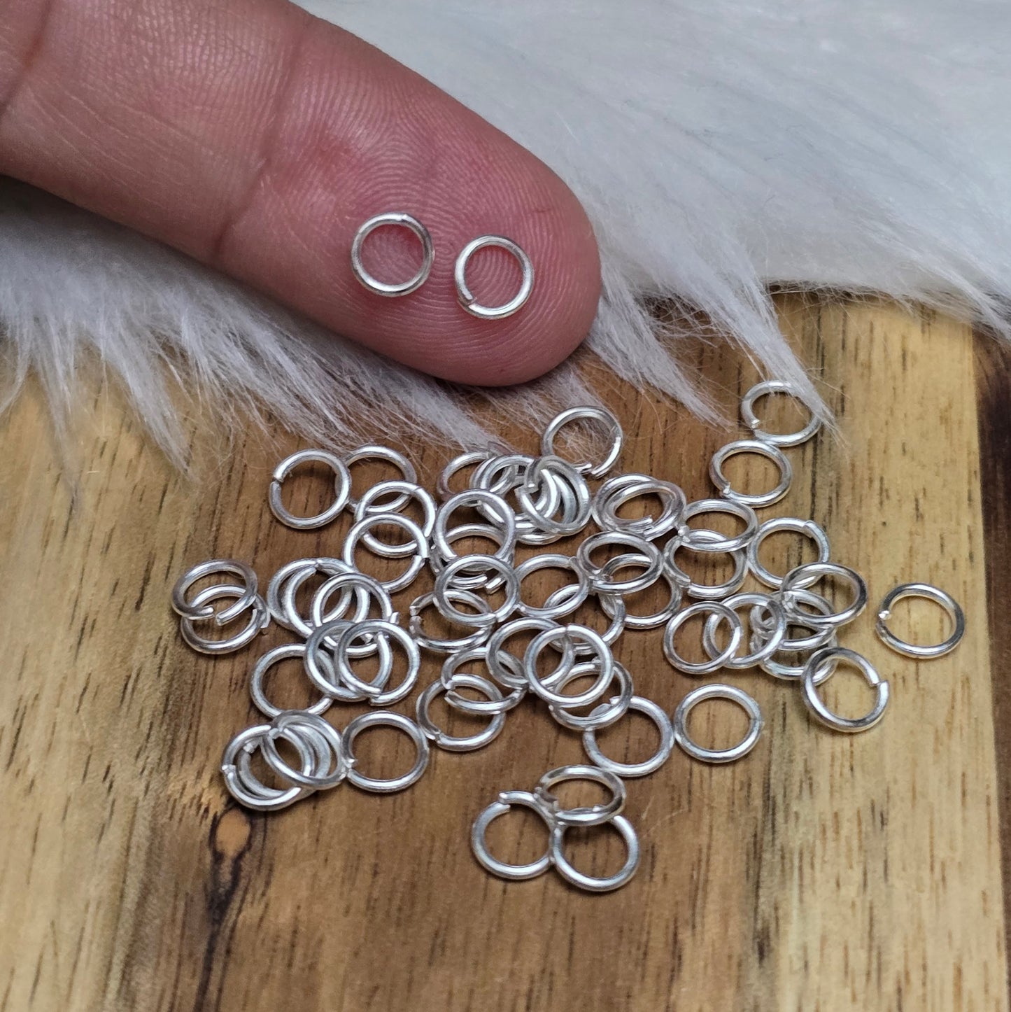 Das Bild zeigt 50 offene Biegeringe in versilbert mit einem Durchmesser von 5mm, ein unverzichtbares Zubehör für die Schmuckherstellung. Ideal um Charms und Verschlüsse zuverlässig zu befestigen.