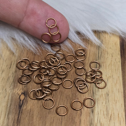Das Bild zeigt 50 offene Biegeringe in antik kupferfarbig mit einem Durchmesser von 5mm, ein unverzichtbares Zubehör für die Schmuckherstellung. Ideal um Charms und Verschlüsse zuverlässig zu befestigen.