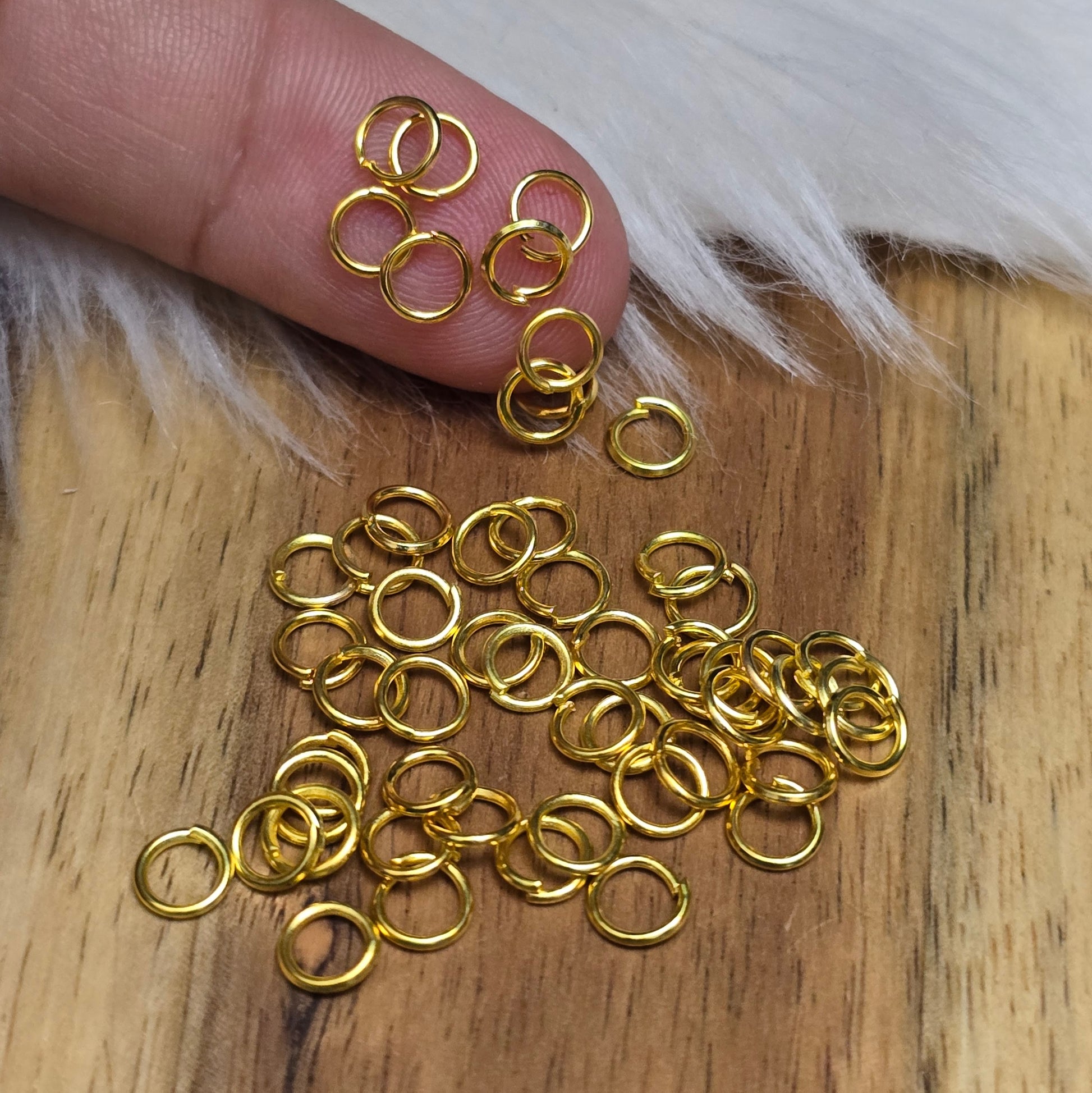 Das Bild zeigt 50 offene Biegeringe in vergoldet mit einem Durchmesser von 5mm, ein unverzichtbares Zubehör für die Schmuckherstellung. Ideal um Charms und Verschlüsse zuverlässig zu befestigen.