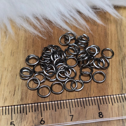 Das Bild zeigt 50 offene Biegeringe in gunmetal black mit einem Durchmesser von 5mm, ein unverzichtbares Zubehör für die Schmuckherstellung. Ideal um Charms und Verschlüsse zuverlässig zu befestigen.