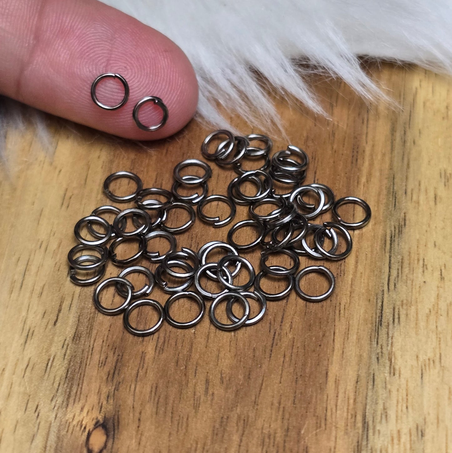 Das Bild zeigt 50 offene Biegeringe in gunmetal black mit einem Durchmesser von 5mm, ein unverzichtbares Zubehör für die Schmuckherstellung. Ideal um Charms und Verschlüsse zuverlässig zu befestigen.