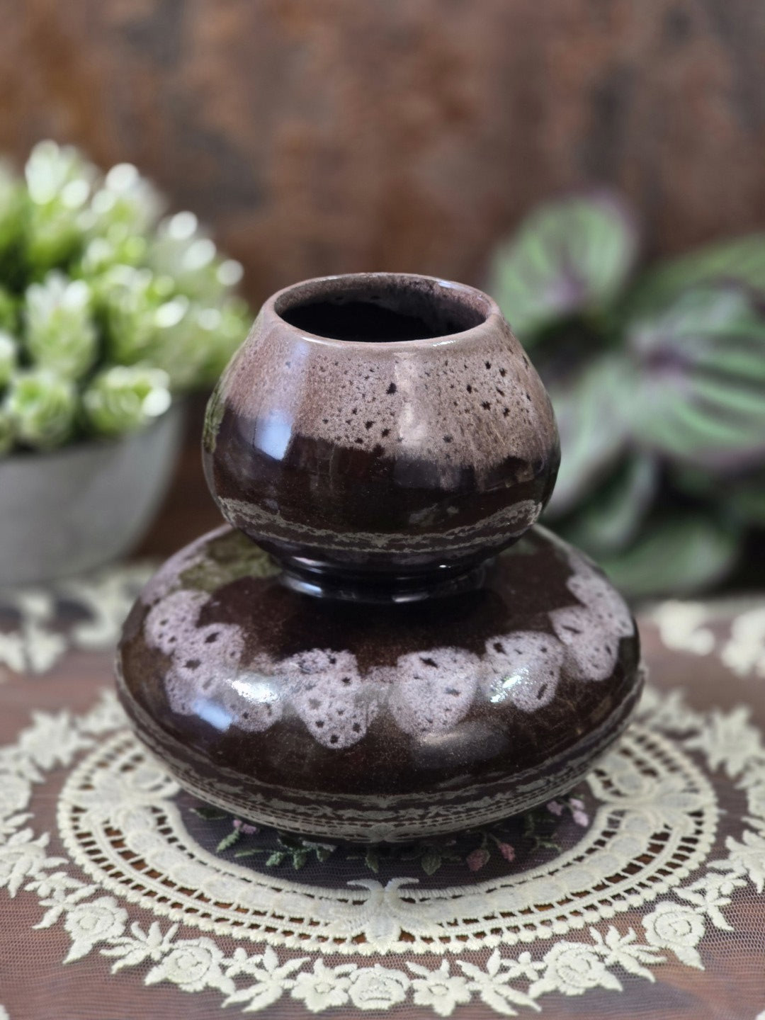 Vintage Keramikvase mit zweistufiger Kugelform, dunkelbrauner Glasur und hell gesprenkeltem Dekor auf einer Spitzendecke.