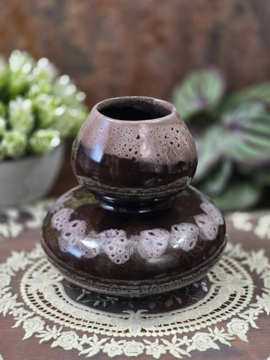 Vintage Keramikvase mit zweistufiger Kugelform, dunkelbrauner Glasur und hell gesprenkeltem Dekor auf einer Spitzendecke.