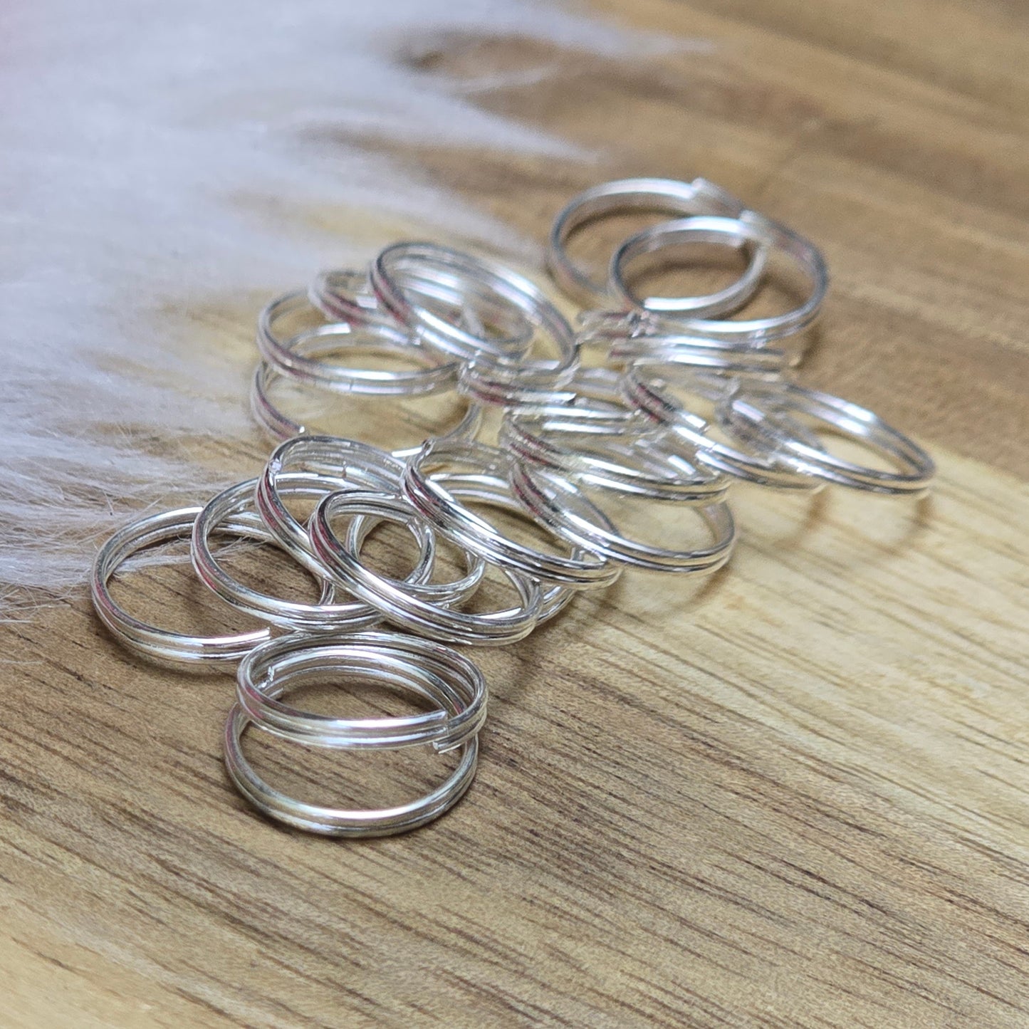 Das Bild zeigt 20 doppelte Binderinge in versilbert mit einem Durchmesser von 9,7mm. Die Verbindungsringe sind ein unverzichtbares Zubehör für die Schmuckherstellung. Durch ihre doppelte Wicklung bieten sie eine besonders stabile und sichere Verbindung, sodass Anhänger, Charms und Verschlüsse zuverlässig befestigt bleiben.