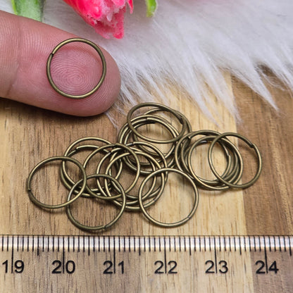 Das Bild zeigt 20 offene Biegeringe in antik bronzefarbig mit einem Durchmesser von 12,3mm. Die Verbindungsringe sind ein unverzichtbares Zubehör für die Schmuckherstellung. Ideal um Charms und Verschlüsse zuverlässig zu befestigen.