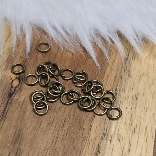 Das Bild zeigt 30 offene Biegeringe mit 4,4mm Durchmesser in antik bronzefarbig, perfekt für die Schmuckherstellung. Sie eignen sich hervorragend als Anhängerösen für Kettenanhänger oder als Verbindungsringe in verschiedenen Designs.