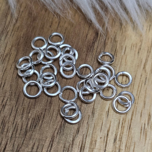 Das Bild zeigt 30 offene Biegeringe mit 4mm Durchmesser, perfekt für die Schmuckherstellung. Sie eignen sich hervorragend als Anhängerösen für Kettenanhänger oder als Verbindungsringe in verschiedenen Designs.