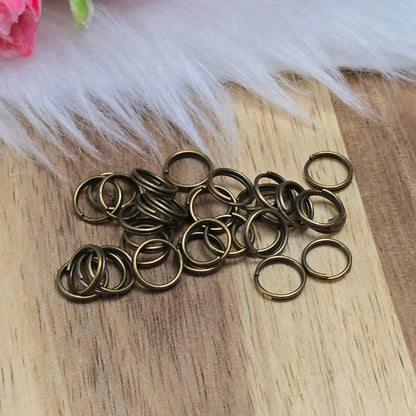 Das Bild zeigt 30 doppelte Binderinge in antik bronzefarbig mit einem Durchmesser von 7mm. Die Verbindungsringe sind ein unverzichtbares Zubehör für die Schmuckherstellung. Durch ihre doppelte Wicklung bieten sie eine besonders stabile und sichere Verbindung, sodass Anhänger, Charms und Verschlüsse zuverlässig befestigt bleiben.